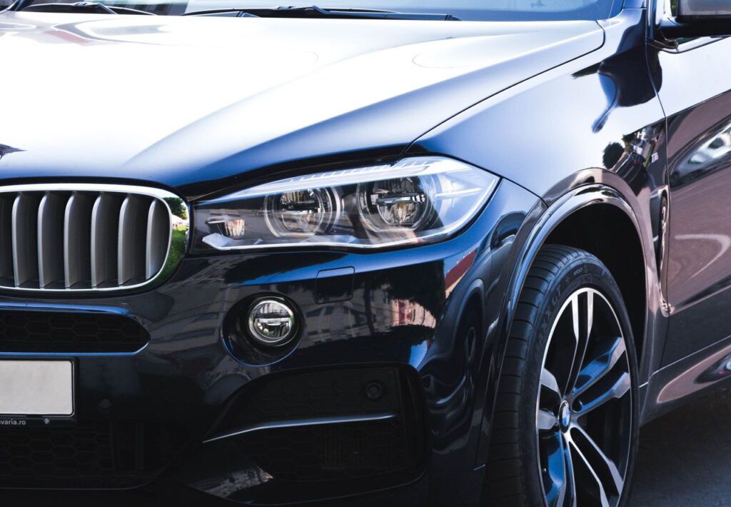 pexels photo Close-up of a black luxury car showcasing intricate headlight and front grille details.