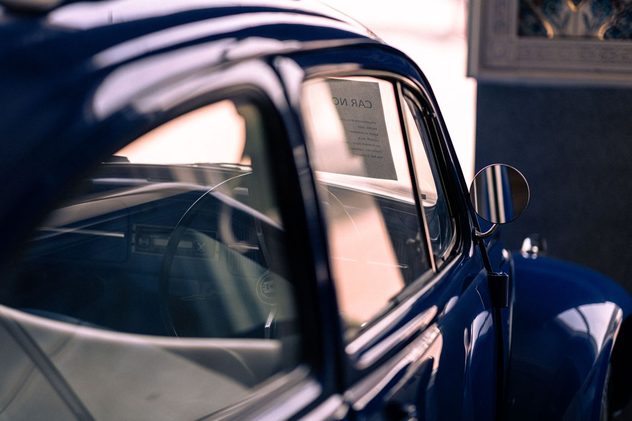 A classic blue vintage car with reflections, capturing an elegant retro style.