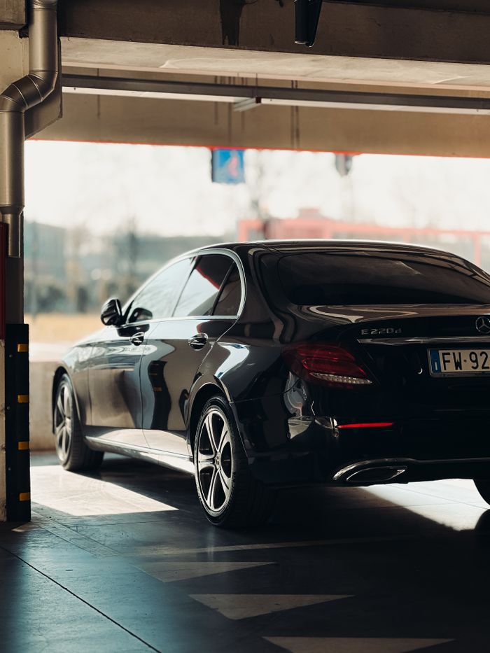 Sleek black luxury sedan parked in an indoor garage, showcasing elegant design.