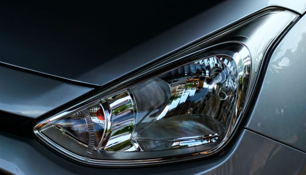 pexels photo 38030206 Detailed close-up of a car headlight on a sleek silver vehicle, showing intricate reflective elements.